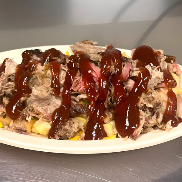 Chuck's BBQ pulled pork and cheese fries, generously drizzled with rich barbecue sauce.