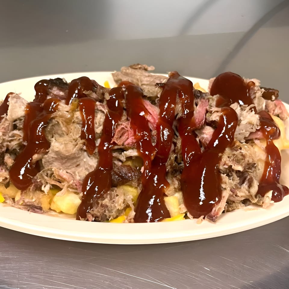 Chuck's BBQ pulled pork and cheese fries, generously drizzled with rich barbecue sauce.