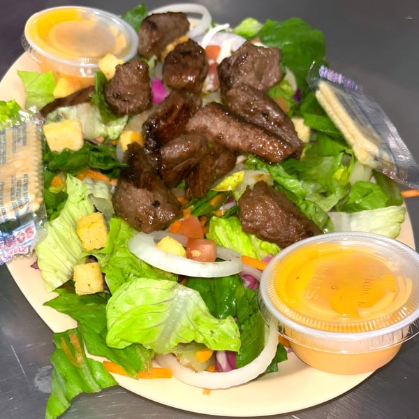 Chuck's BBQ steak salad with lettuce, onions, croutons, and two cups of dressing.